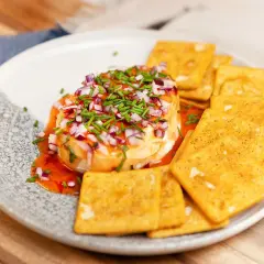 Ost med hackad rödlök och gräslök, ringlad med söt chilisås. Serveras med kex.