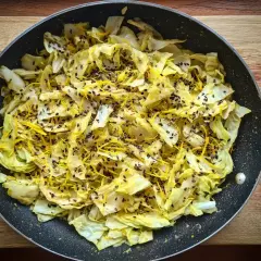 Stekt spetskål med citronskal och svarta sesamfrön i en stekpanna. Enkel och god rätt att grilla spetskål.