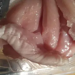 Rå kycklingfiléer i en plastförpackning. Ser inte aptitligt ut, undrar hur smakar dålig kyckling.