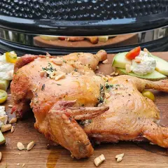 Hel kyckling i ugn, gyllene och saftig, serverad med melon, färskost och körsbärstomater.
