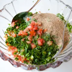 En skål med färska ingredienser för Zeinas tabbouleh: hackad persilja, tomat och bulgur.