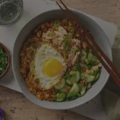 En skål med stekt ris med ett stekt ägg, kyckling och gurka. Enkel och god egg rice.