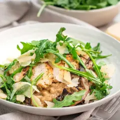 En krämig svamprisotto med kyckling, toppad med ruccola och parmesan. En härlig rätt för en mysig middag.