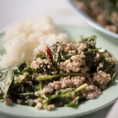 En tallrik med ris och en kryddig kötträtt med färska örter och chili. En smak av äkta thai kryddor.