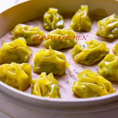En ångad bambukorg fylld med gyllene afghanska mantu-dumplings.