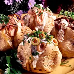 Fyra läckra bakade potatisar med olika fyllningar, toppade med gräddfil, bacon, oliver och örter. En festlig och mättande rätt!