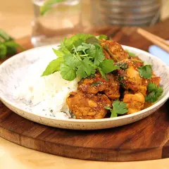 Kycklingrätt med ris, toppad med färska örter och en hint av citrongräs. En smakrik asiatisk måltid.