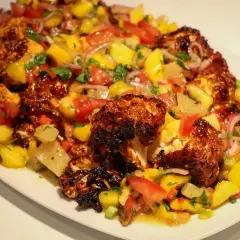Ugnsbakad blomkål med en fräsch mangosalsa. Ett perfekt recept för en somrig middag.
