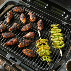 Grillens dag firas med saftiga kycklingvingar och grillade paprikor på en portabel grill.