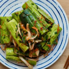 En tallrik med krispig gurka marinerad i en kryddig kimchi-sås, redo att avnjutas som ett läckert recept med kimchi.
