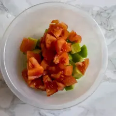 Tärnad tomat och gurka i en skål, redo att bli en fräsch sallad shirazi.