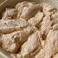 Råa kycklingbitar i en krämig marinad. Denna yoghurtmarinerade kyckling ser ut att bli fantastiskt god!