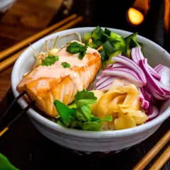 En läcker lax poke-bowl med ris, gurka, rödlök och ingefära. En krämig sås toppar den saftiga laxfilén.