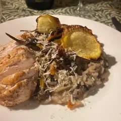 En härlig tallrik med tryffelrisotto med kyckling, toppad med krispiga potatisskivor och riven parmesan. En riktig smakupplevelse!