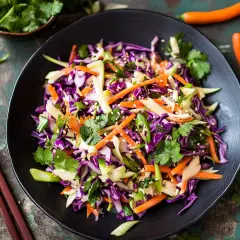 En färgglad asiatisk sallad med rödkål, morötter och koriander, toppad med sesamfrön. Perfekt som tillbehör eller lätt lunch.