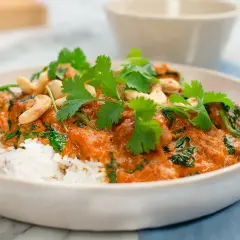 En krämig palak chicken med ris, toppad med cashewnötter och färsk koriander. En smakrik indisk rätt.