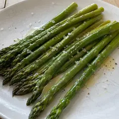 En tallrik med perfekt kokt sparris, lätt oljad och strödd med flingsalt och peppar. En enkel och god rätt att koka sparris till.