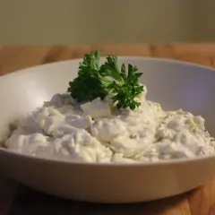 En skål med krämig tarator djej, toppad med färsk persilja.