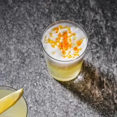 Två uppfriskande drinkar, en med citronskiva, den andra toppad med skum och yuzu-zest. Perfekt för ett yuzu recept.