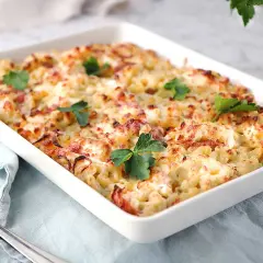 En krämig gratäng med makaroner, ost och bacon, perfekt för ett gott ostsås recept. Garnerad med färsk persilja.