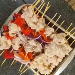 Shish tawook-spett på spett med kyckling, röd paprika och lök, redo att grillas.