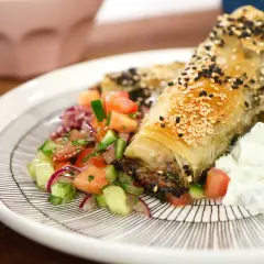 Krispiga filodegsrullar med sesamfrön, serverade med en fräsch tomatsallad och yoghurt. Ett utsökt burek recept!