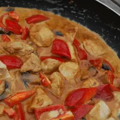 En smakrik chicken karahi i en panna med möra kycklingbitar, röd paprika och champinjoner i en krämig sås.