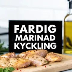 Färdig kyckling på ett skärbräde, redo att serveras. Texten "FARDIG MARINAD KYCKLING" syns i bakgrunden.
