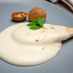 Krämig bechamelsås på en tallrik, med muskotnötter och persilja. Perfekt för att frysa in och använda senare.