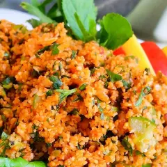 En närbild på en läcker kisir-sallad, full av bulgur, örter och grönsaker. Perfekt för ett lätt och smakrikt mellanmål.