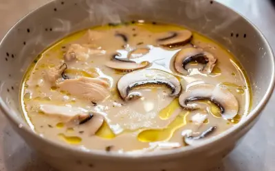 En ångande skål med krämig tom kha gai, fylld med möra kycklingbitar och saftiga champinjoner.
