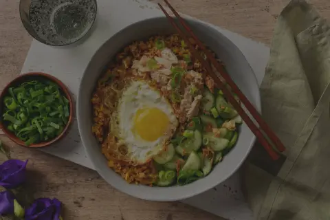 En skål med stekt ris med ett stekt ägg, kyckling och gurka. Enkel och god egg rice.