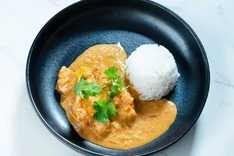 En krämig butter chicken med ris, garnerad med färsk koriander. En klassiker som alltid smakar gott.