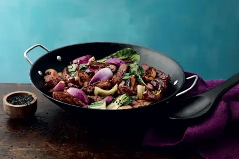 En smakrik kycklingwok med teriyakisås, full av grönsaker och toppad med svarta sesamfrön.