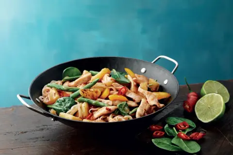 Kycklingwok med nudlar, gröna bönor, paprika och en antydan till wok hei. Serveras med lime och chili.