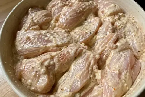 Råa kycklingbitar i en krämig marinad. Denna yoghurtmarinerade kyckling ser ut att bli fantastiskt god!