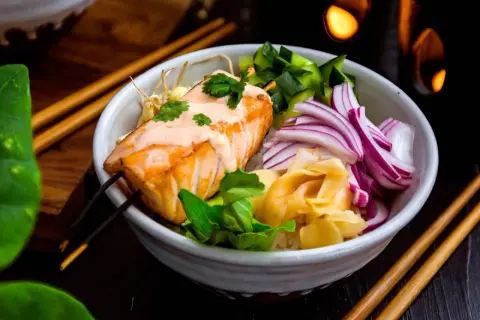 En läcker lax poke-bowl med ris, gurka, rödlök och ingefära. En krämig sås toppar den saftiga laxfilén.