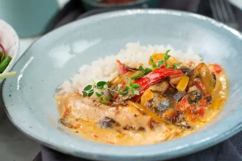 En krämig kycklinggryta med ris, paprika och champinjoner. En härlig rätt som passar perfekt för en mysig middag.
