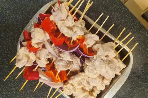 Shish tawook-spett på spett med kyckling, röd paprika och lök, redo att grillas.