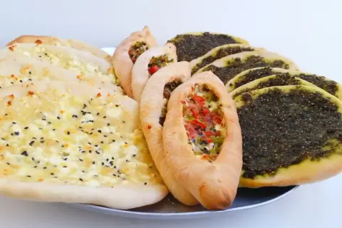En bricka med manakish: ost med svarta sesamfrön, grönsaksfyllda och med za'atar. Perfekt för ett snabbt manakish recept!