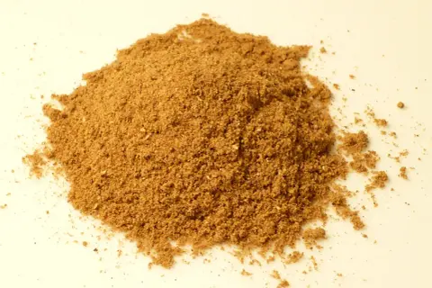 En hög med finmalet, brunt kryddpulver. Detta är en bild som visar vad som kan finnas i garam masala, en populär indisk kryddblandning.