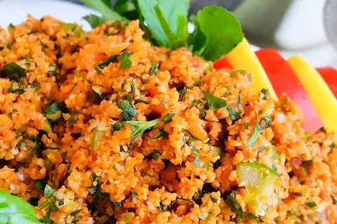 En närbild på en läcker kisir-sallad, full av bulgur, örter och grönsaker. Perfekt för ett lätt och smakrikt mellanmål.