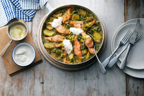 En härlig ugnsbakad lax med potatis och purjolök, perfekt för ett enkelt lax recept. Serveras med en klick gräddfil.