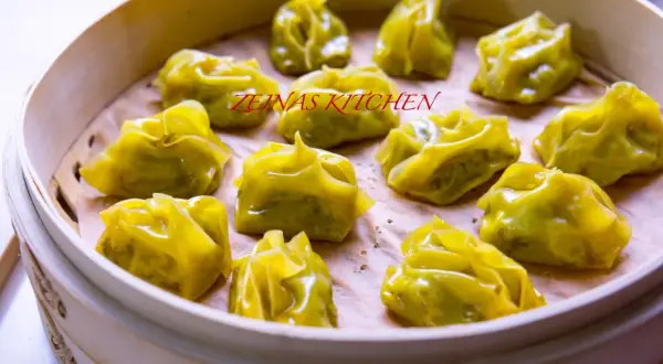 En ångad bambukorg fylld med gyllene afghanska mantu-dumplings.