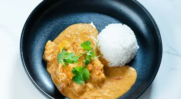 En krämig butter chicken med ris, garnerad med färsk koriander. En klassiker som alltid smakar gott.