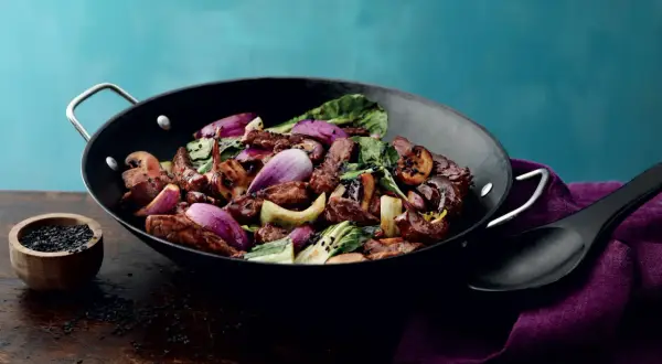 En smakrik kycklingwok med teriyakisås, full av grönsaker och toppad med svarta sesamfrön.