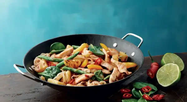 Kycklingwok med nudlar, gröna bönor, paprika och en antydan till wok hei. Serveras med lime och chili.
