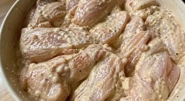 Råa kycklingbitar i en krämig marinad. Denna yoghurtmarinerade kyckling ser ut att bli fantastiskt god!