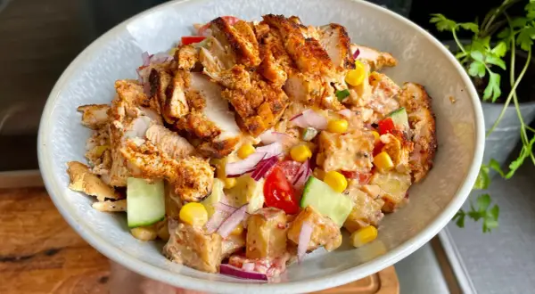 En härlig kyckling kebab-sallad med grillad kyckling, potatis, majs, gurka, tomat och rödlök i en krämig dressing. Perfekt för en snabb och god lunch!
