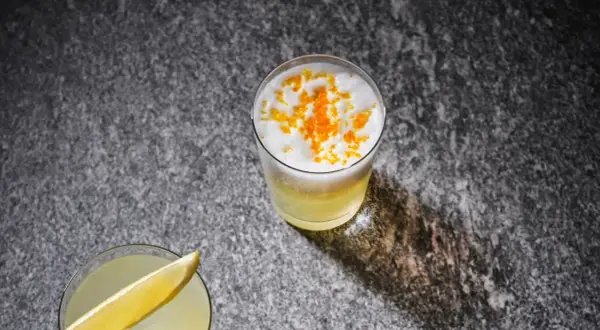 Två uppfriskande drinkar, en med citronskiva, den andra toppad med skum och yuzu-zest. Perfekt för ett yuzu recept.